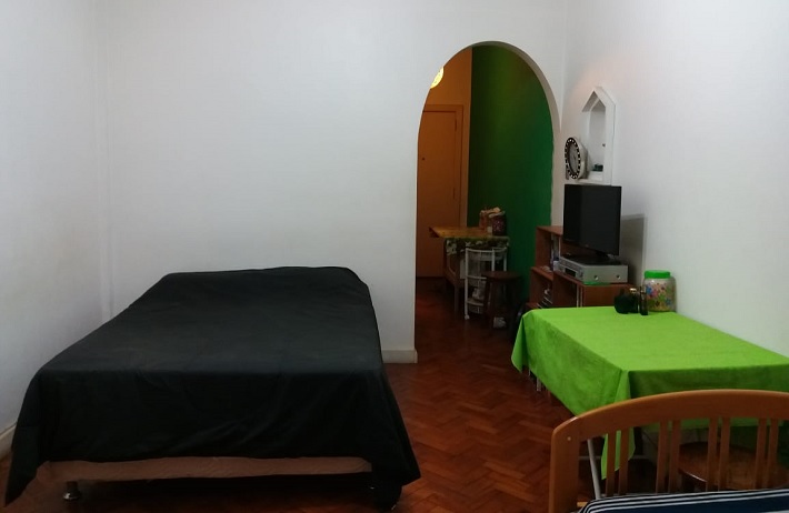 Cama de casal e mesa do quarto no apartamento de Copacabana