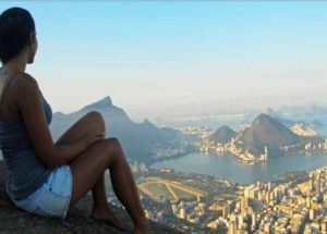 Moça sentada vendo a vista do Dois Irmãos