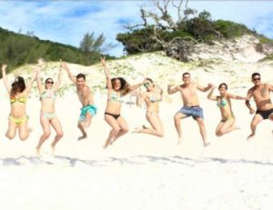 Turistas pulando e fazendo pose em Arrial do Cabo